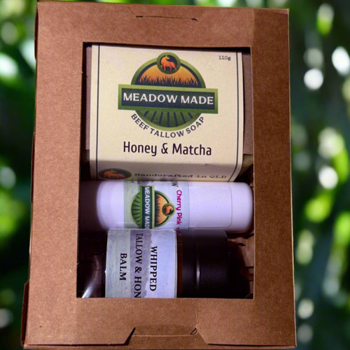Meadow Made Honey & Matcha soap and balm set in a brown box with a green blurred background.